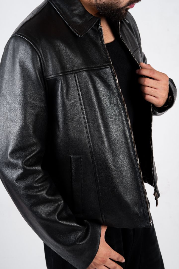 Black leather jacket worn by a person on a white background blaatan