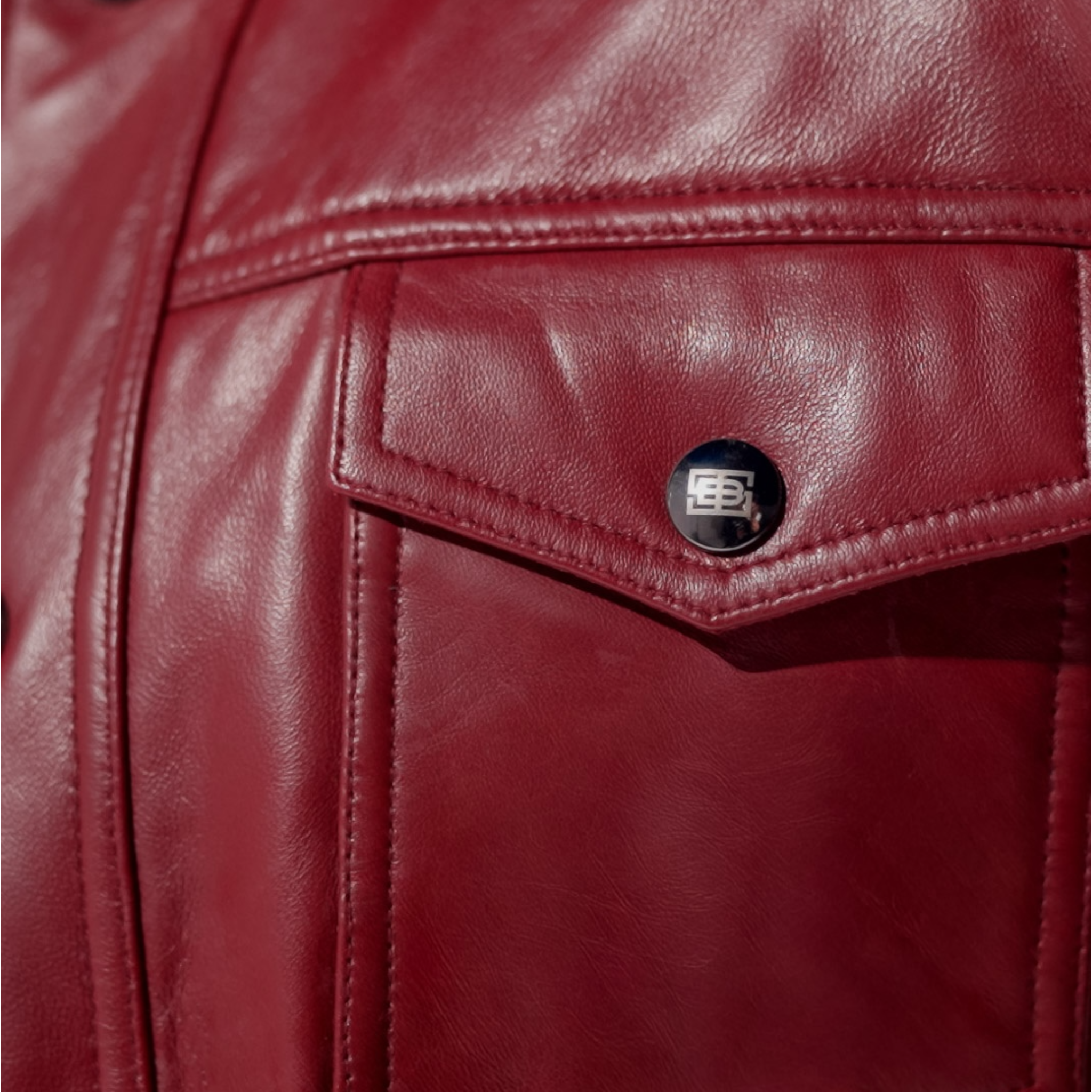 Close-up of a red leather jacket with a brand logo on the pocket. Blaatan The Garnet Crimson Edition Crimson Burgundy Leather Jacket for Men