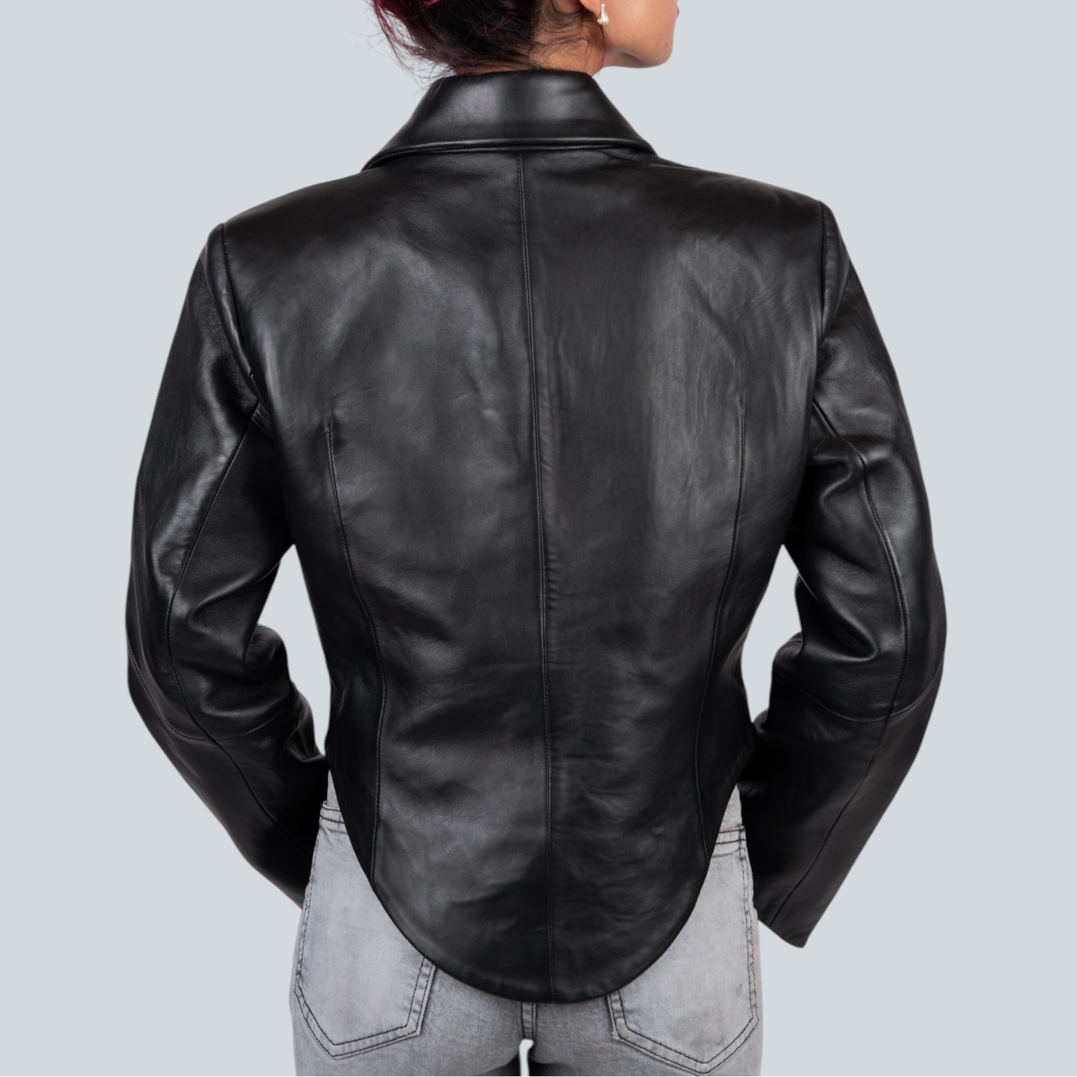 Person wearing a black leather jacket on a light gray background